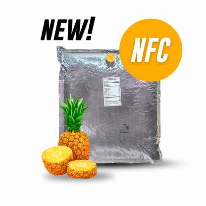 A large silver foil bag of pineapple-flavored powder or granules with a small yellow cap, shown on a white background with whole and sliced pineapples at the bottom left. Black text reads 'NEW!' and an orange circle reads 'NFC'.